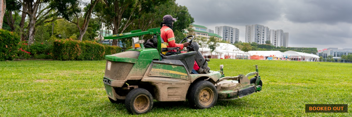 Landscaping business owner answering an inbound lead call on his phone in front of a company truck