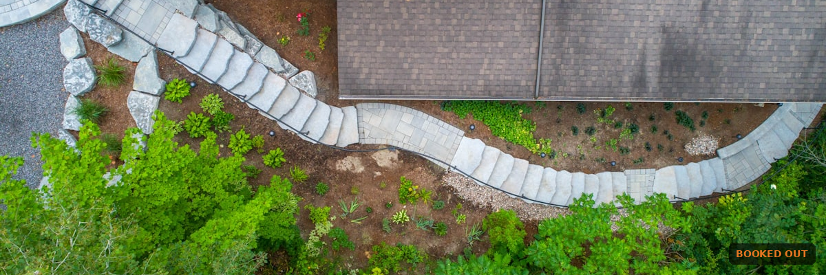 Smartphone showing a text conversation between a landscaping company and a homeowner confirming a service appointment, illustrating SMS marketing for landscapers